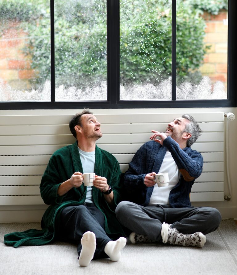 deux hommes souriants assis par terre