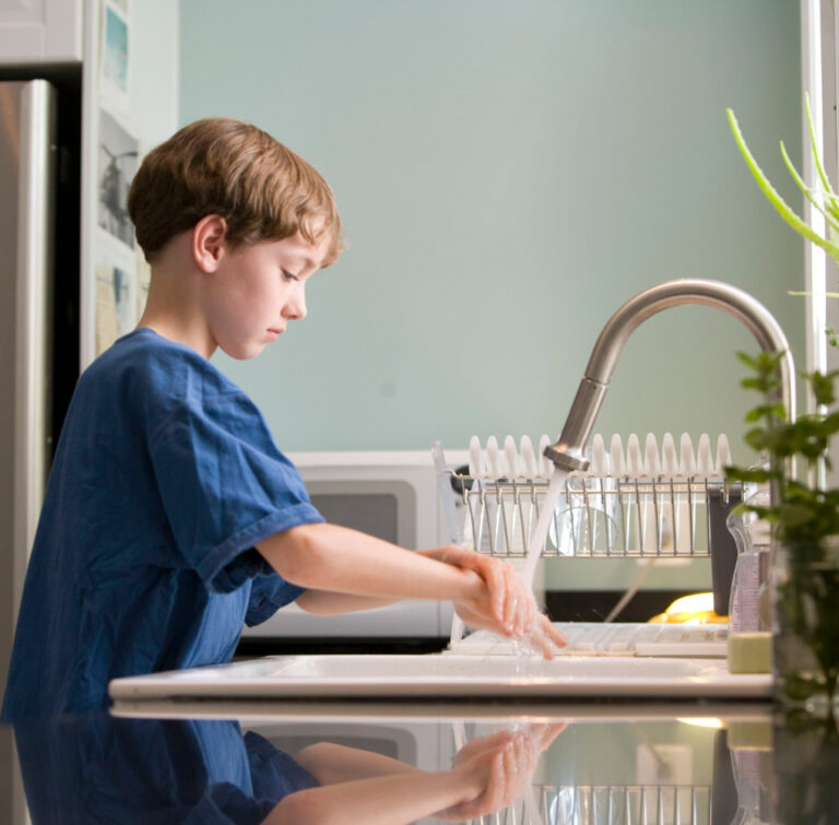enfant qui se lave les mains grâce aux panneaux solaires thermiques