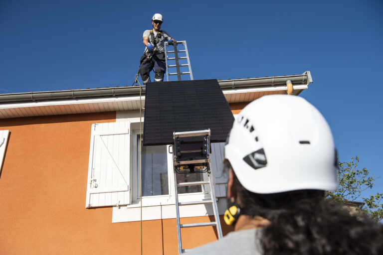 Deux installateurs photovoltaïques sur le toit d'un client particulier