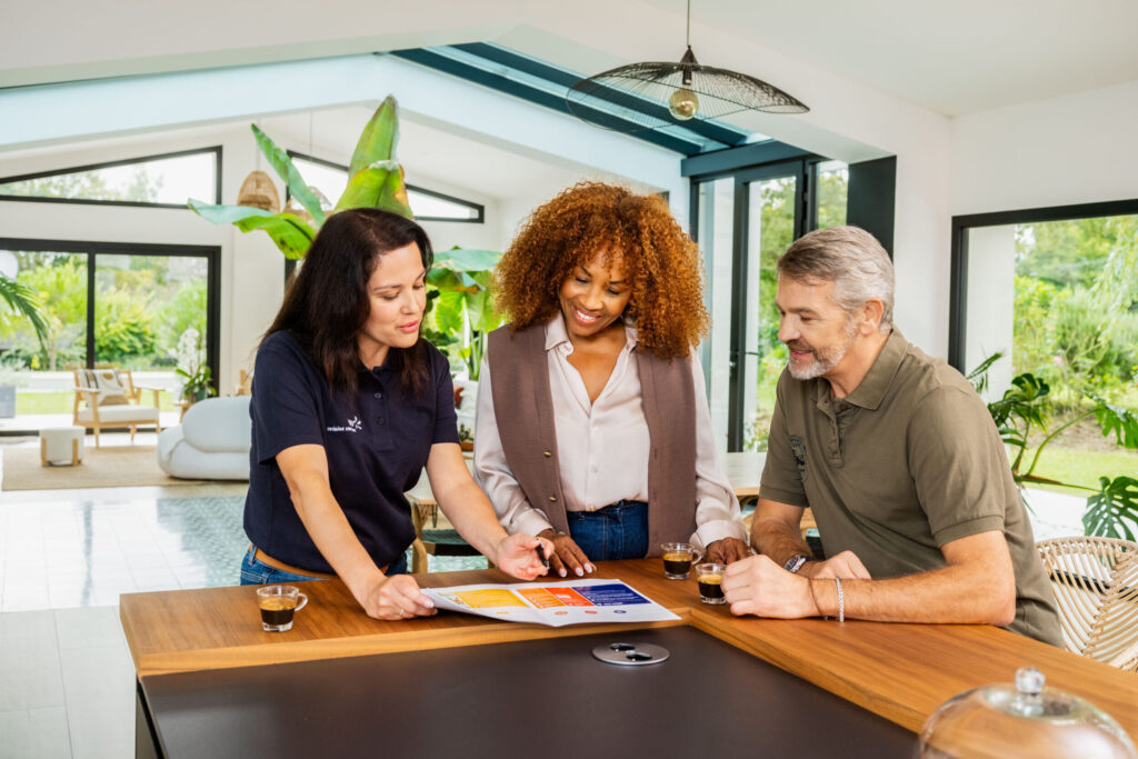 Des personnes qui discutent dans un salon avec une conseillère EDF solutions solaires