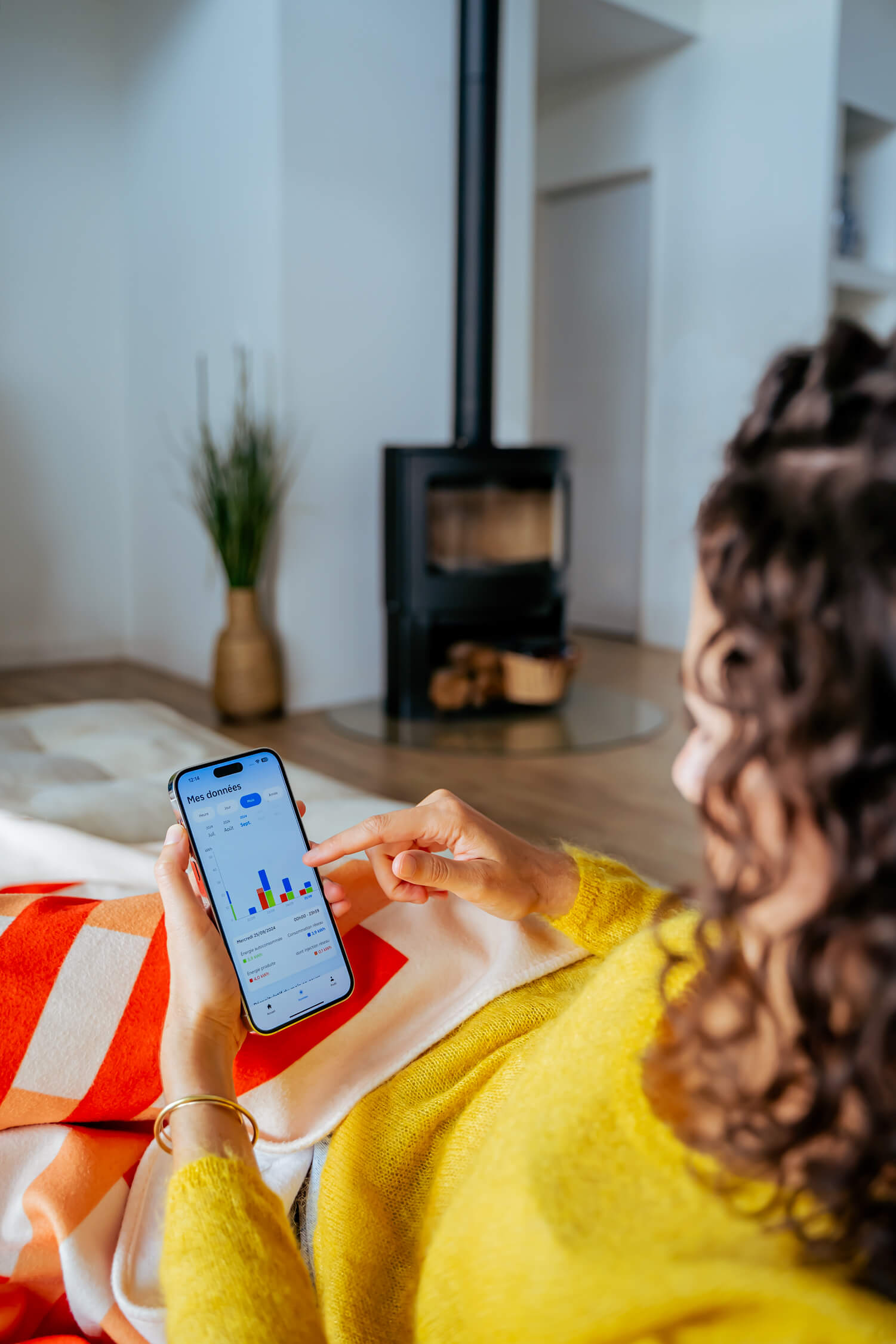 Personne dans son salon qui consulte l'application EDF solutions solaires